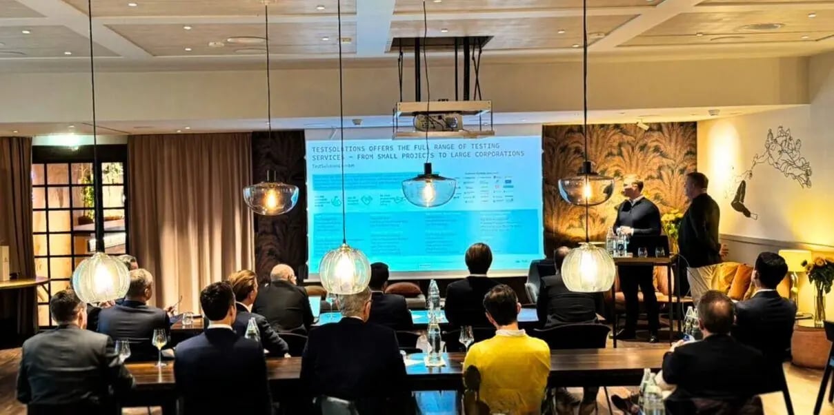 Fachpublikum verfolgt eine Präsentation über Testlösungen und Private Equity in einem stilvollen Veranstaltungsraum mit moderner Beleuchtung.