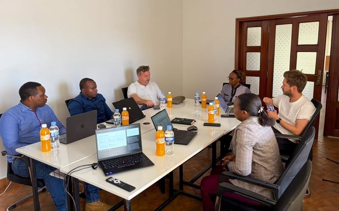 Office scene with 6 people sitting at conference table