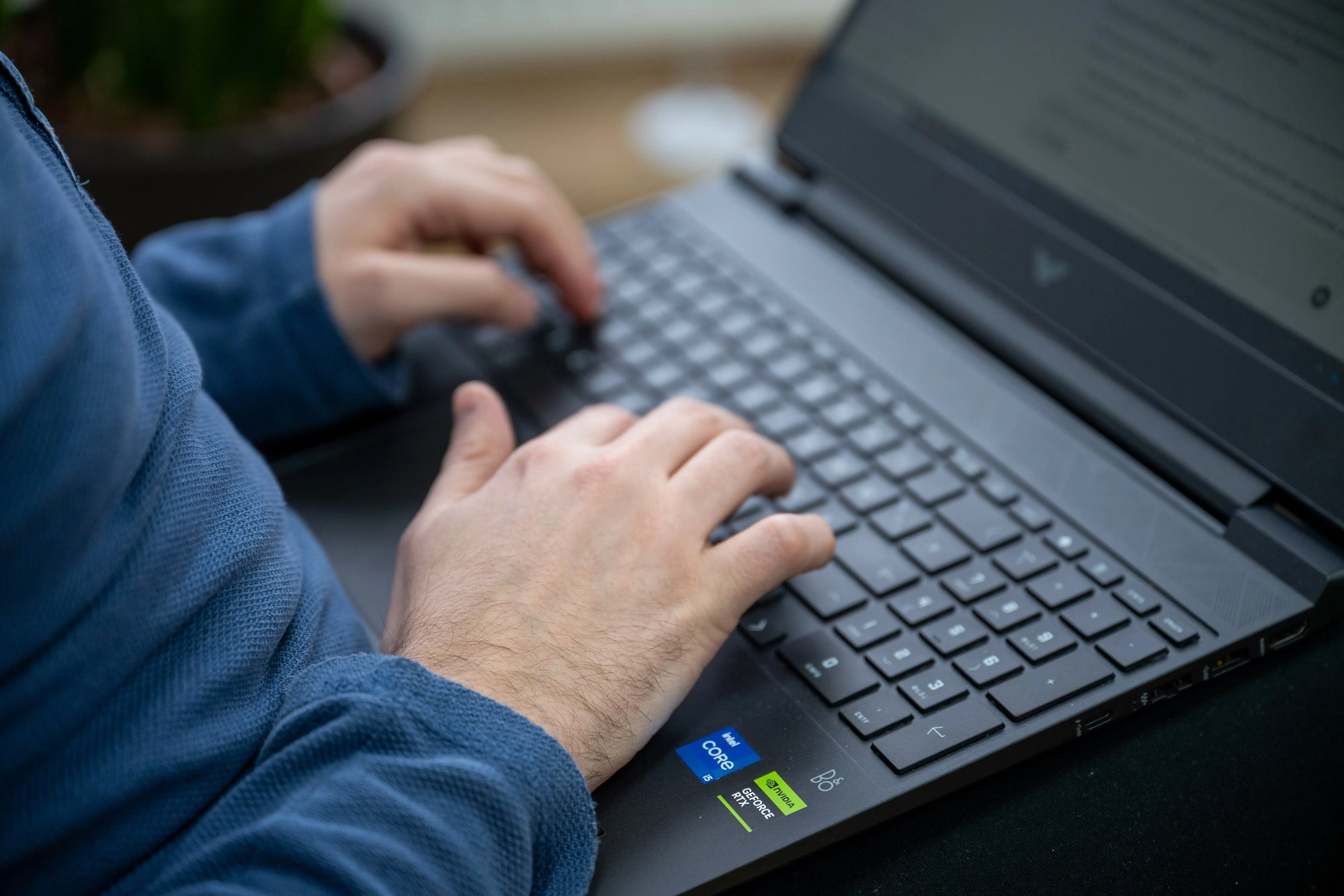 Person typing on a laptop with a black keyboard
