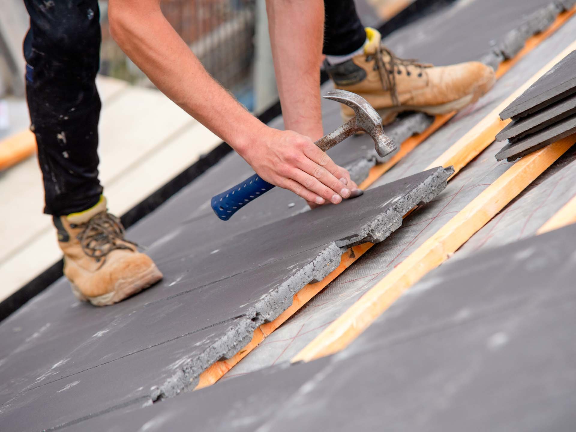Dachdecker repariert Ziegeln am Dach