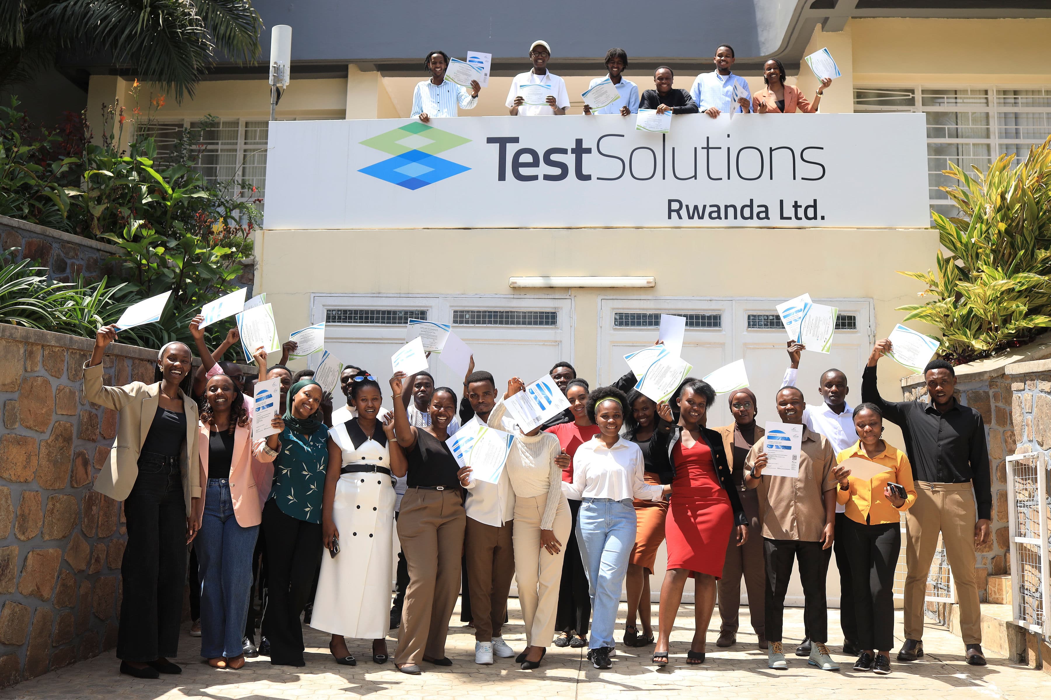 Group photo with Minister of State Yves Iradukunda in front of the TestSolutions Rwanda Office